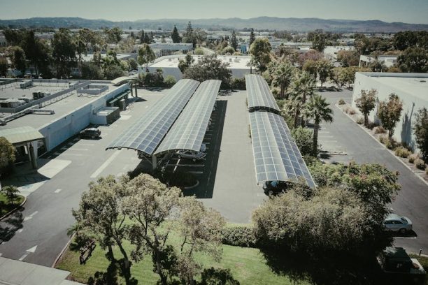 Aerial shot of solar panel installations in a suburban neighborhood under clear skies.